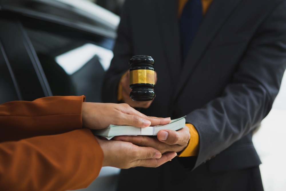 Injured driver reviews compensation chart with lawyer, discussing damages after a serious car accident.